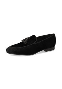 Mocasines de terciopelo negro con una textura trenzada, que presentan una punta redonda y un adorno de borlas decorativas en la parte frontal. Tacón bajo y plano.