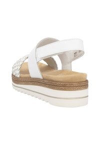 Sandale blanche avec un matériau tressé sur le talon, une sangle réglable et une semelle intérieure rembourrée avec une semelle intermédiaire texturée et une semelle extérieure en caoutchouc.