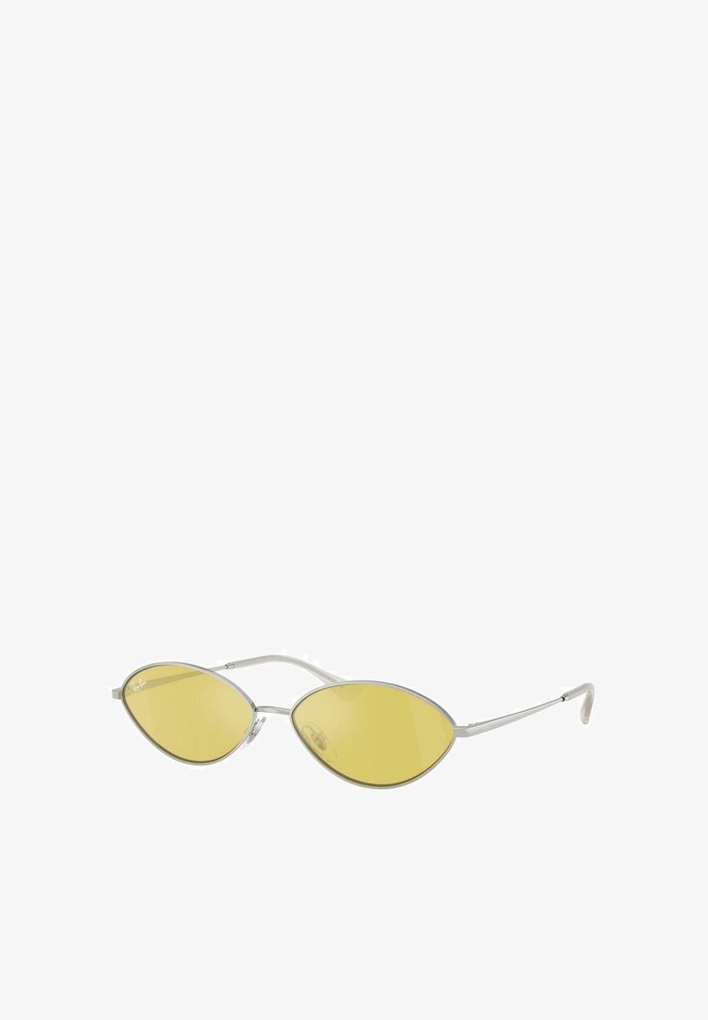 Gafas de sol con tinte amarillo, con una forma alargada y ovalada de las lentes y un delicado marco plateado. Presentan un diseño minimalista y brazos de varilla afilados.