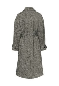 Houndstooth-patroon jas in zwart-wit, met een ceintuur in de taille, opgerolde mouwen en een brede kraag, gemaakt van textured stof.