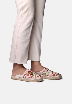Alpargatas sin cordones bordadas en color crema con patrones florales en rosa y verde. Suelas de yute natural y parte superior de tela texturizada.