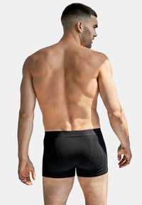 Svarta boxerkalsonger tillverkade av ett mjukt, stretchigt material, som har en åtsittande design och en mjuk midjeresår för komfort.