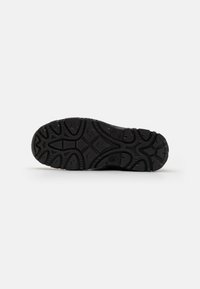 Suela de zapato de goma negra con un diseño de banda de rodadura que presenta surcos y crestas para tracción. Bordes suaves y diseño de fondo plano.
