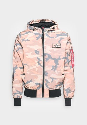 Camouflage jacket in pink and gray tones, featuring a front zipper, hood, and elastic cuffs and hem. Includes a logo patch and red accent tag.