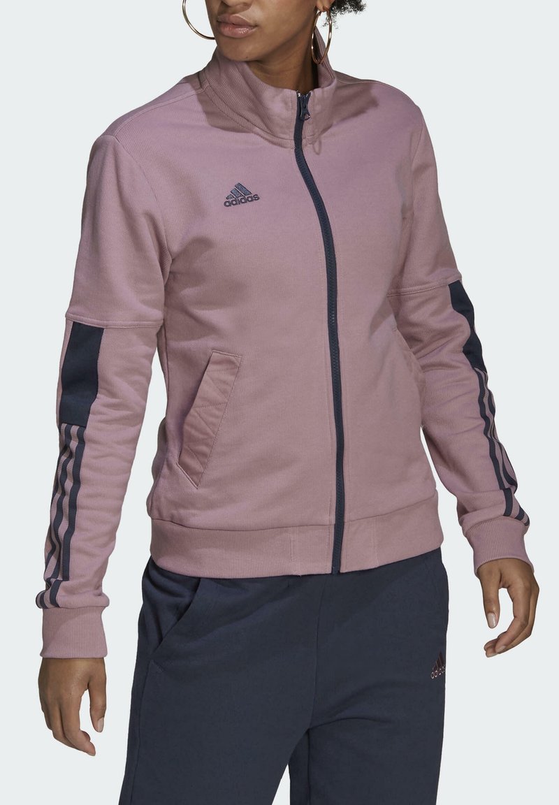 Roze jack met ritssluiting en donkerblauwe accenten, voorzien van een hoge kraag, geribbelde manchetten en zijzakken. Adidas-logo op de borst.