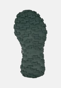 Semelle de chaussure en caoutchouc verte avec des rainures profondes, présentant une surface texturée et le mot "CAMPER" en relief. Conçue pour l'adhérence et la durabilité.