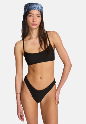 Ensemble bikini côtelé noir composé d'un haut bralette rectangulaire à fines bretelles et d'un bas taille haute à découpe en forme de V à l'avant.