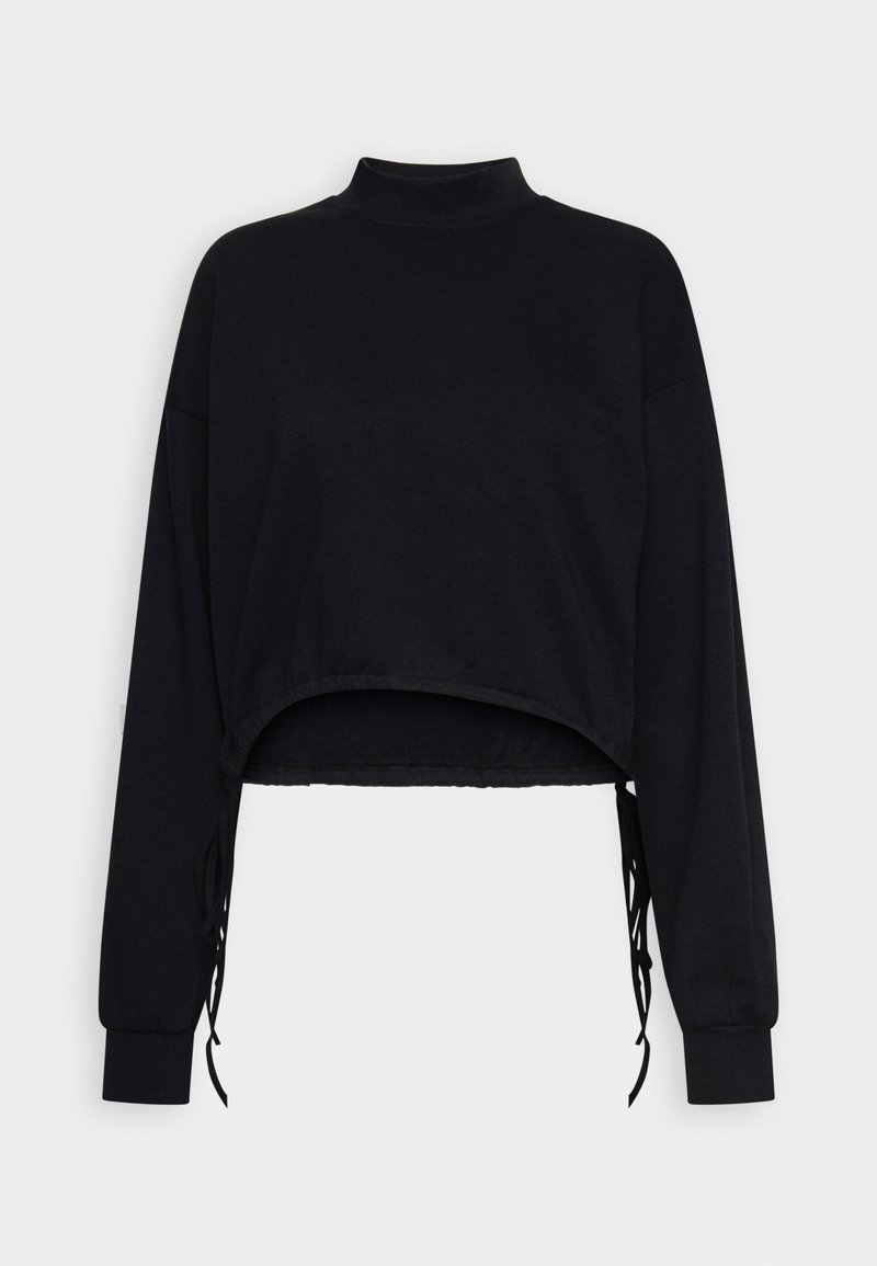 Haut noir court à manches longues avec col montant et liens latéraux ajustables, présenté à plat sur un fond blanc.