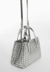 Borsa a mano intrecciata argento con due manici, forma strutturata e design textured. Collo di regolazione attaccato per comodità.