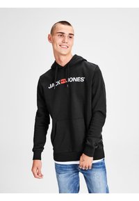 Sort hættetrøje med frontlomme og hvid "JACK & JONES" logo. Har justerbare snore og ribbede manchetter. Bæres med blå jeans.