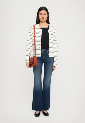 White cardigan with horizontal striped pattern, paired with a black top and flared blue jeans. Accessories include a small brown crossbody bag.