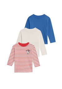 Drie longsleeve shirts: één blauwe, één crèmekleurige en één witte met rode strepen, met een cartoonfiguur en de tekst "BIG APPLE" op de voorkant.