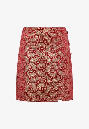 Red skirt featuring a paisley pattern in gold, with a fitted design and side buttons. Made from a smooth fabric with a slight sheen.