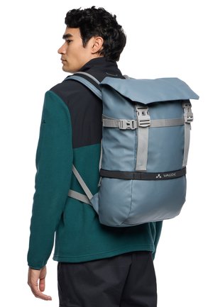 Gray roll-top backpack with adjustable gray straps, featuring a durable material and a front buckle closure. Logo displayed at the bottom.