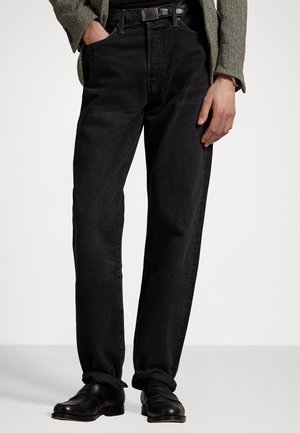 Sorte denim jeans med lige ben, båret med et sort bælte og sorte sko; stoffet har en glat tekstur og minimal detaljer.