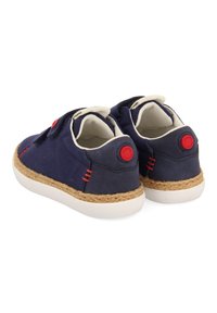 Zapatillas de lona navy con suelas de goma blanca, acentos rojos en contraste y un envoltorio de yute texturizado alrededor de la suela. Diseño con correa de velcro.