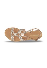 Sandalo piatto tan con cinturini metallici intrecciati, soletta imbottita e design minimalista. Presenta una chiusura a loop e fibbia alla caviglia.