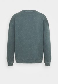 Felpa a maniche lunghe, di un verde scuro sbiadito, con collo a giro e polsini e orlo a coste, mostrata dal retro su uno sfondo bianco semplice.