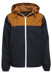 Giacca da uomo caratterizzata da un corpo blu navy con una sezione superiore marrone, zipper bianco, cappuccio regolabile e polsini elastici. Tessuto dalla texture liscia.