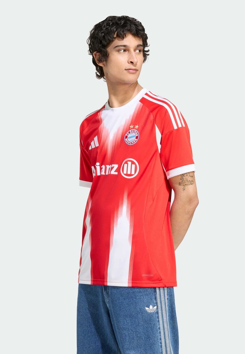 Punane ja valge gradient spordisärg lühikeste varrukatega, millel on Bayern Munichi logo ja Adidas' ribad õlgadel.