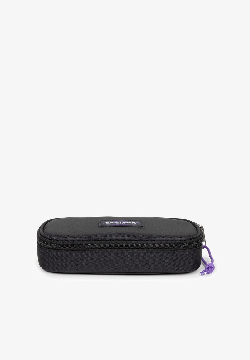 Astuccio rettangolare nero con superficie testurizzata, dotato di chiusura a zip e linguetta viola. Include una toppa con il logo Eastpak sul davanti.