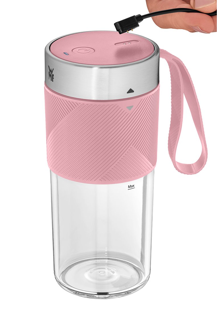 Rosa tragbare Mixer mit strukturiertem Griff, klarem Behälter, der mit "Max" gekennzeichnet ist, metallener Oberseite mit Power-Taste und einer Hand, die ein Verbindungskabel darüber hält.