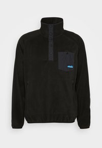 Pullover in pile nero con colletto alto, patta con bottoni a scatto e taschino sul petto in tessuto nero a contrasto con dettagli del logo. Presenta tasche laterali.