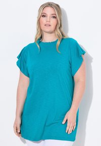 Teal krátký rukáv top s volánovým výstřihem a uvolněným střihem. Lehká látka s hladkým povrchem, navržená pro pohodlí a každodenní nošení.