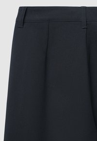 Dunkelblaue, plissierte Hosen mit glatter Textur, ausgestattet mit einem flachen Bund und ohne sichtbare Beschläge oder Taschen. Klassisches, maßgeschneidertes Design.