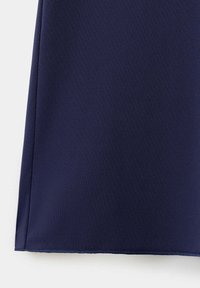 Tissu bleu marine foncé avec un ourlet droit et une couture visible courant verticalement près du bord gauche.