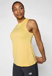 Geel sport tanktop met een ronde halslijn, gestructureerde stof en een klein blauw logo op de borst. Glad afwerking, mouwloos ontwerp.