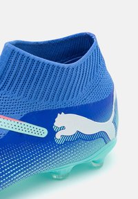 Scarpino da calcio blu con collare alla caviglia in maglia texturizzata, design gradiente, logo bianco e tacchetti trasparenti.