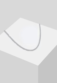 Collier chaîne en argent avec maillons entrelacés, doté d'une finition polie. Design plat reposant sur un fond à surface géométrique.