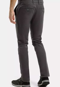 Szare, lekkie spodnie o dopasowanym kroju, z tylnymi kieszeniami zapinanymi na guziki. Połączone z czarnymi trampkami do codziennego noszenia.