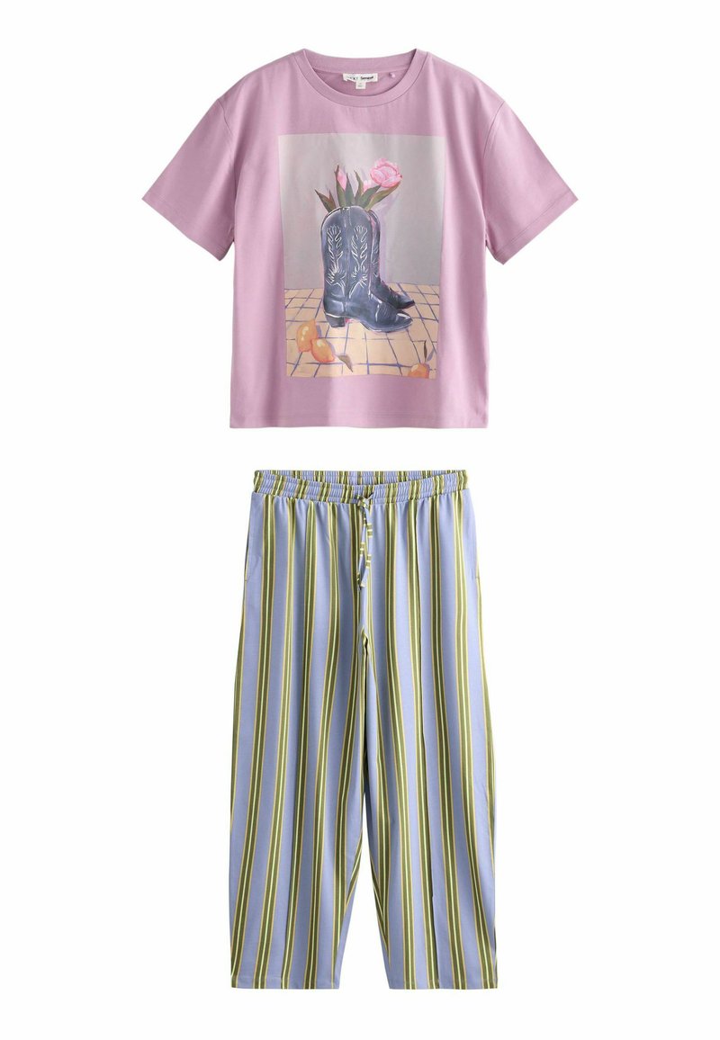 Short pink t-shirt with a graphic of cowboy boots and flowers; paired with light blue and green striped loose-fitting pants.