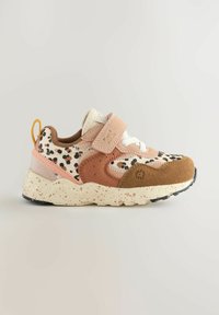 Sportssko med prikmønster i beige og brun, med lyserøde ruskindsdetaljer og en spraglet beige gummisål. Med velcrorem.