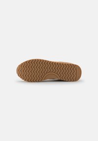 Rubber outsole with a wavy pattern, brown color. Features an embossed number "37" and brand detail near the heel. Smooth edges.