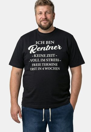 Lächelnder Mann mit einem schwarzen T-Shirt, auf dem weißer deutscher Text über einen beschäftigten Rentner steht, der erst in vier Wochen wieder freie Termine hat.