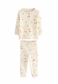 Cremefarvet pyjamasæt lavet af blødt stof. Langærmet top med knapdetalje og et mønster af hjerter i pink og brunt over det hele. Bukser med elastisk talje.