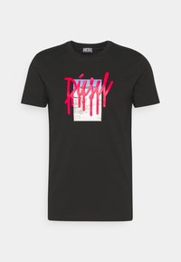 Černé bavlněné tričko s centrálním grafickým motivem v modré a růžové barvě, se silným stylizovaným textem přetékajícím přes něj. Krátké rukávy a kulatý výstřih.