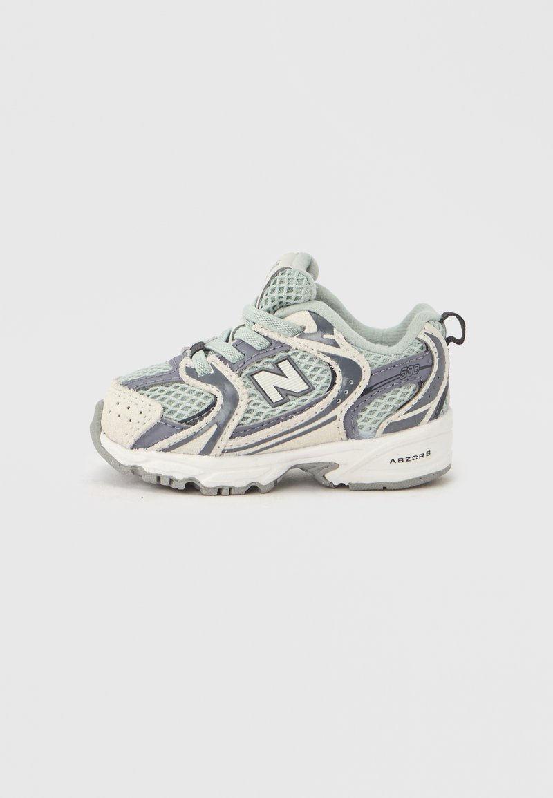 Αθλητικά παπούτσια για παιδιά σε γκρι και μέντα πράσινο διχτυωτό υλικό, με λευκές και γκρι λεπτομέ ρειες, στρογγυλή μύτη και αντιολισθητική σόλα. Διαθέτει κορδόνια και ταινία έλξης.