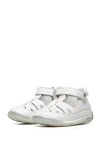 Witte leren schoenen met meerdere kruissluitingen en een klittenbandsluiting, met een gestructureerde, lichtdoorzichtige rubberen zool.