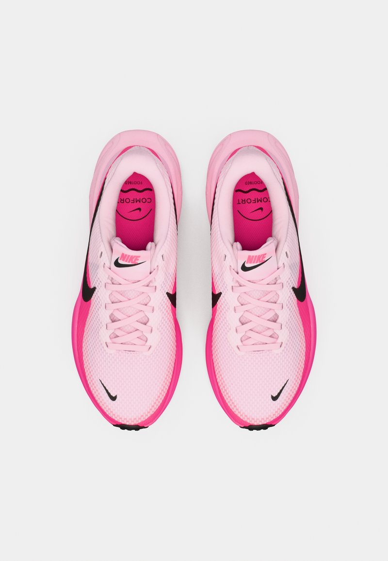 Zapatillas de running Nike con parte superior de malla en rosa claro, acentos en rosa intenso, logotipo Swoosh negro y cordones blancos. Diseño centrado en la comodidad.