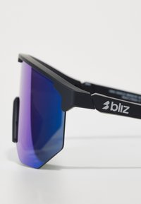 Schwarze Sportsonnenbrille mit kantigem Design, verlaufenden Blau-Violett-Gläsern und matter Oberfläche. Mit einem Logo auf dem Rahmen.