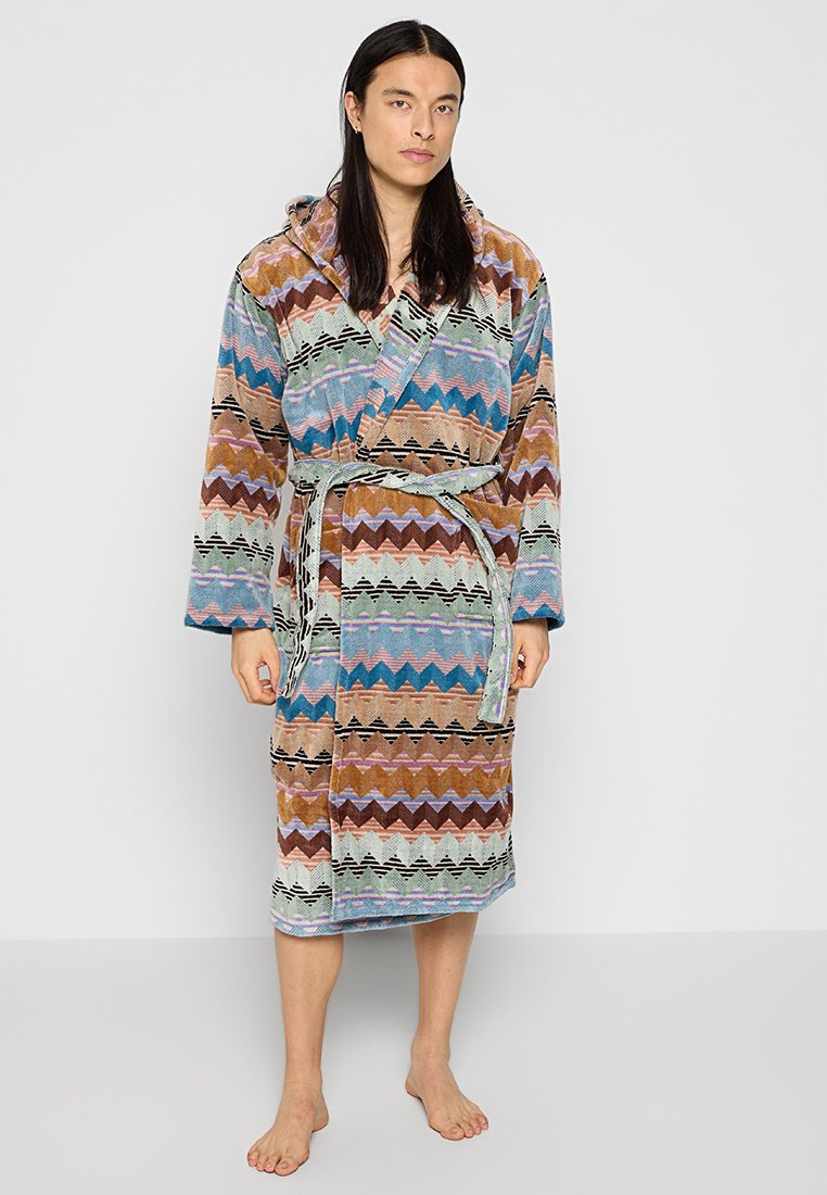 Accappatoio multicolore con un motivo a zigzag in tonalità di blu, marrone, rosa e verde. Realizzato in tessuto morbido con vita regolabile e cappuccio.