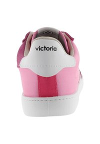 Baskets roses avec une tige en daim et en tissu, dotées d'une semelle blanche, de rayures roses contrastantes et du logo 'victoria' à l'arrière.