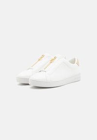 Baskets blanches en cuir à enfiler avec une finition lisse, présentant des zips dorés à l'avant et des accents beiges au niveau du talon. Semelle en caoutchouc.