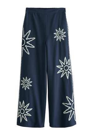 Marineblaue Hosen mit weitem Bein und elastischem Bund, mit großer weißer Sonnenstrahlen-Stickerei auf der Vorderseite und gemusterten Seitenstreifen.