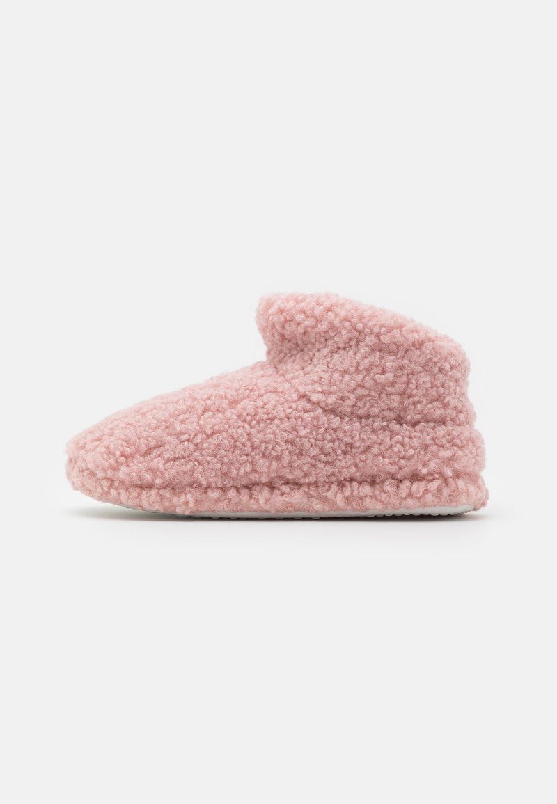 Rosa fluffiga tofflor tillverkade av texturerat material. Har en enkel design med rundad tå och en mjuk, vikbar kant vid vristen.