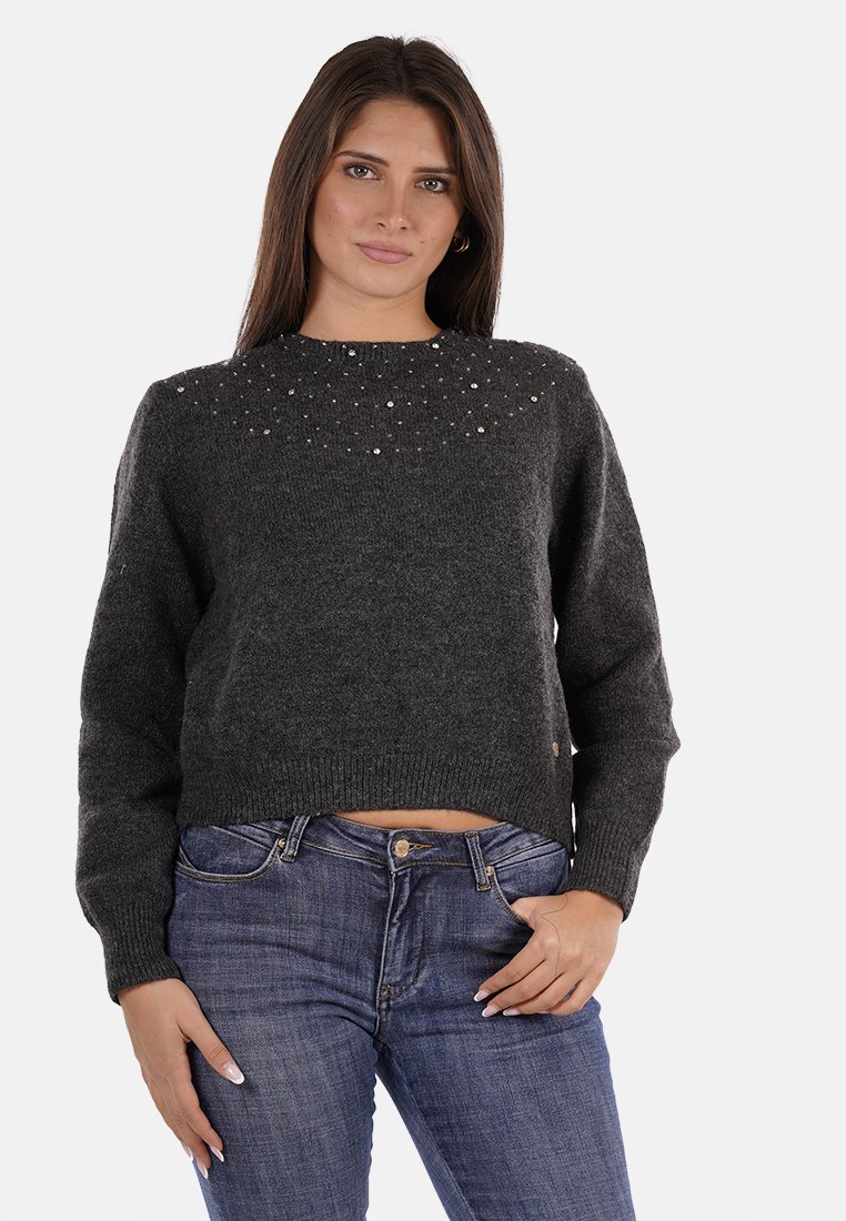 Pullover grigio corto con finitura testurizzata, adornato con piccoli gioielli lungo il colletto rotondo. Abbinato a jeans blu.